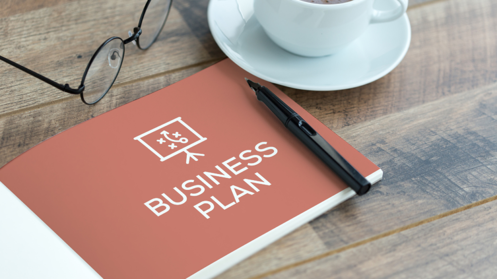 Notebook labeled Business Plan on a desk, representing the first steps to starting an online business.