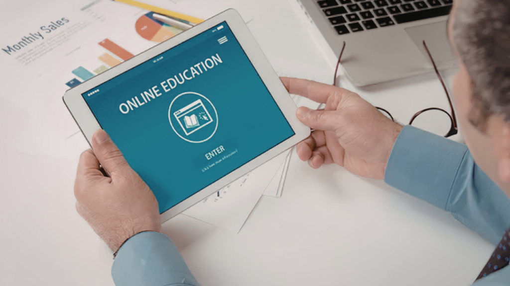 Person holding a tablet showing an online education screen, representing learning the core skills for online business.